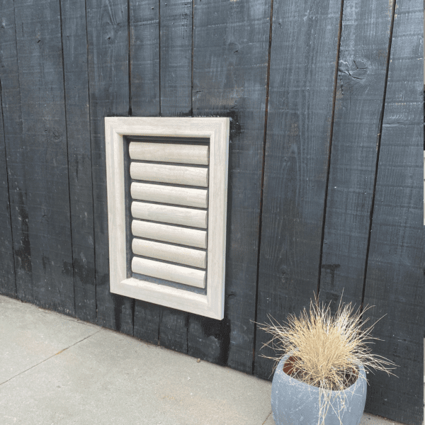 une grande trappe étanche en bois pour un grand chien tel qu'un labrador ou un lévrier, installée par Tomsgates dans un mur en bois peint en noir, résistant au cambriolage.