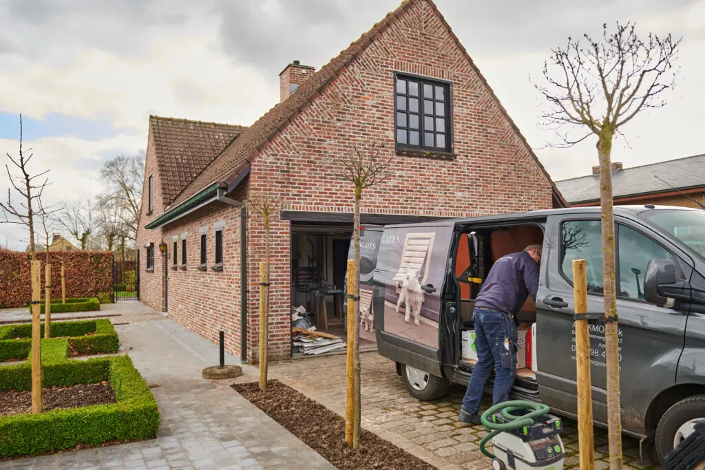 Groot hondenluik in stenen muur plaatsen door installateur van Tomsgates